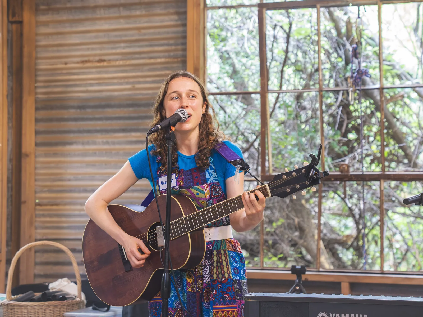 Amber singing and playing guitar at a barn venue