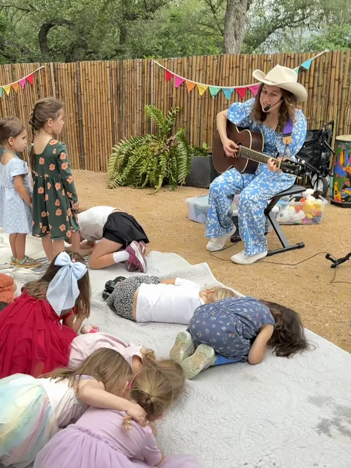 Amber playing guitar for kids at a backyard birthday party