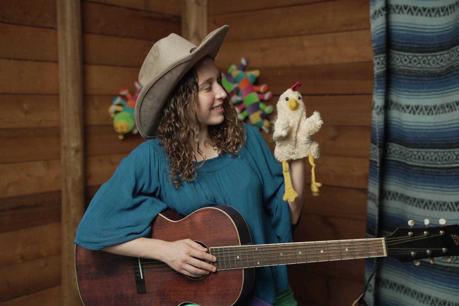 Amber playing guitar with a chicken puppet