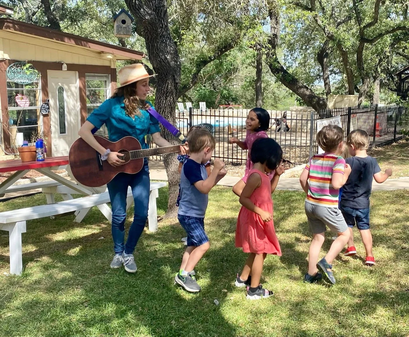 Kids dancing outdoors to guitar during a music class