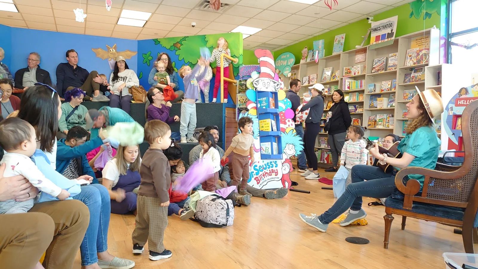 Amber playing guitar at a bookstore storytime concert